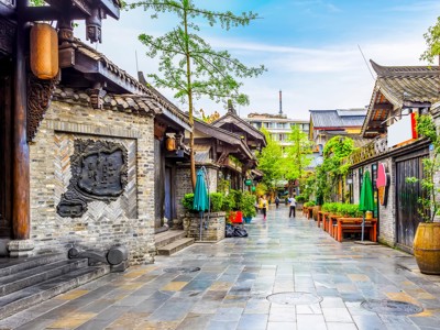 Sfeervolle steeg met traditionele Chinese gebouwen, lantaarns en terrassen in een historisch stadsdeel in China.