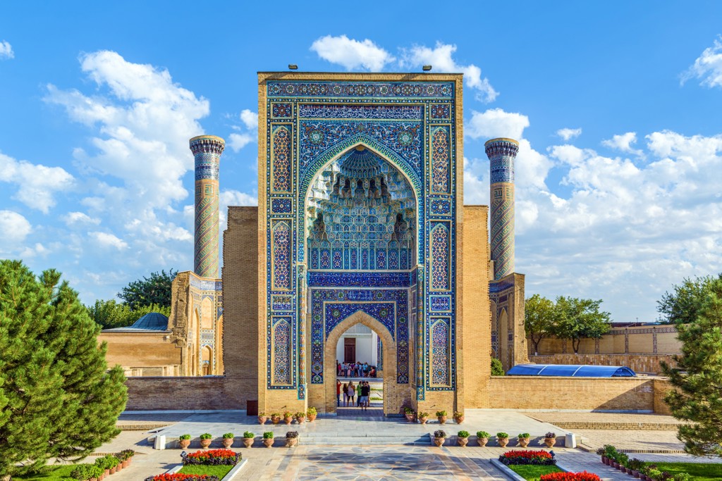 Blauw betegelde toegangspoort met minaretten in Samarkand, highlight van de groepsrondreis Zijderoute.