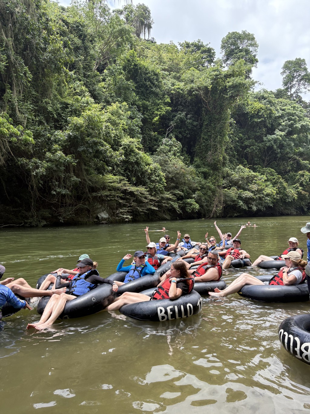 22-35ers genieten van tuben op een rivier in Colombia, omringd door groen regenwoud.