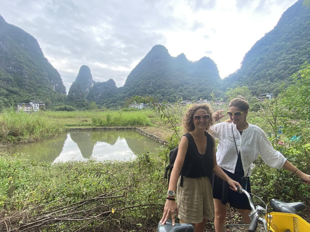 Twee reizigers met fiets bij rijstvelden en karstbergen in Guilin, China.