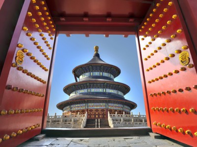 Tempel van de Hemel in Beijing, gezien door een rode poort met gouden studs.