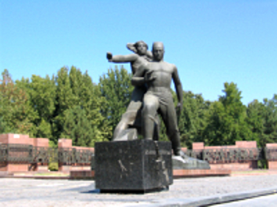 Monument met twee bronzen figuren op een plein langs de Route Zijderoute.