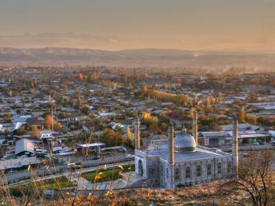 Panoramisch uitzicht op een stad met moskee en minaretten bij zonsondergang langs de Route Zijderoute.