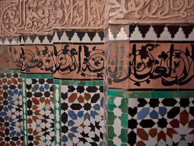 Mozaïektegels en sierlijke kalligrafie op een muur in Andalusië tijdens de rondreis Andalusië.