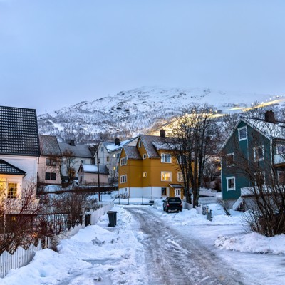 Sneeuwbedekt dorp met kleurrijke houten huizen in Zweeds en Noors Lapland tijdens de winter.