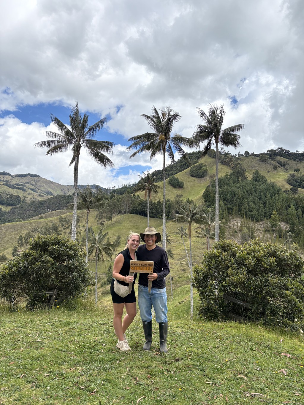 Reizigers tijdens 22-35ers reis Colombia met gids in Cocora Valley tussen hoge palmen en groene heuvels.