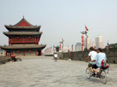 Fietser op de stadsmuur van Xi’an richting de oude stadspoort, Route Zijderoute.
