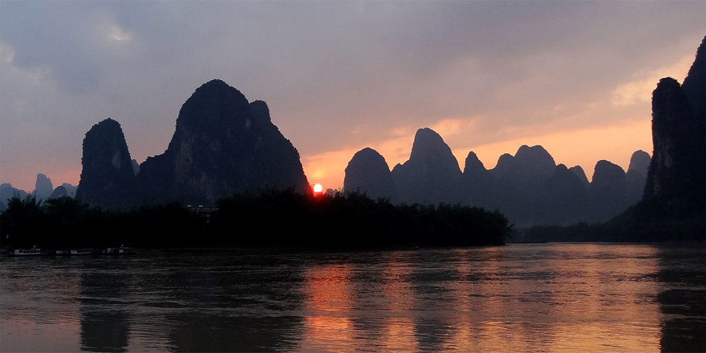 Zonsondergang boven de Li-rivier met karstbergen bij Guilin, China.