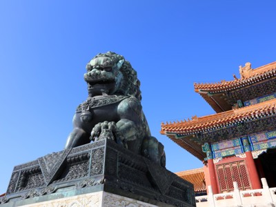 Bronzen leeuwenbeeld bij een traditioneel Chinees paleisgebouw op de Route Zijderoute.