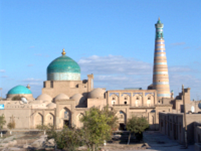 Historische moskee met turquoise koepel en gestreepte minaret langs de Route Zijderoute.
